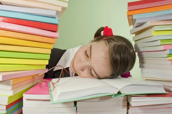 Genç kız kitap yığını üzerinde uyuyor — Stok fotoğraf
