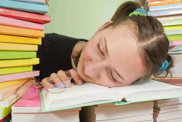 Estudiante chica durmiendo en la pila de libros — Stok fotoğraf
