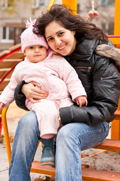 Madre e hija al aire libre en un parque infantil — Foto de Stock