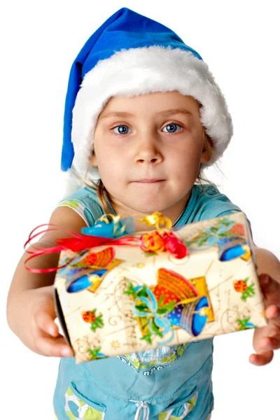 Girl in Santa's hat giving out s present — Stock Photo, Image