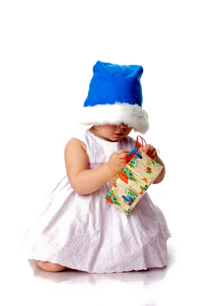 Beautiful baby in Santa's hat with a present — Stock Photo, Image