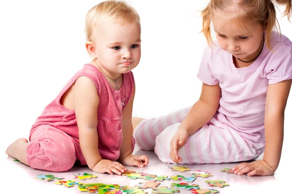 Crianças resolvendo quebra-cabeça isolado no branco — Fotografia de Stock