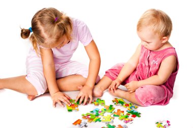 Children solving jigsaw puzzle clipart