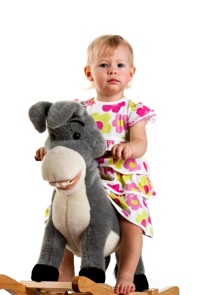 Bebê bonito balançando em um brinquedo burro balançando — Fotografia de Stock