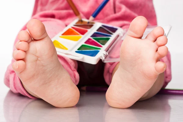 Piedi del bambino con vernice e matite — Foto Stock