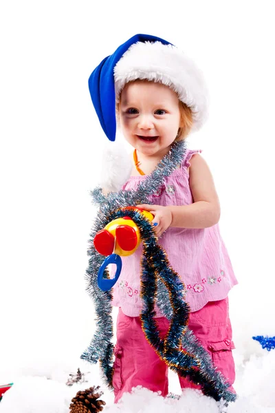 Bambino in cappello di Babbo Natale in fili di lame e neve artificiale — Foto Stock