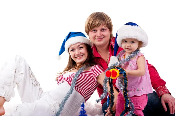 Family in Santa's hat lying in artificial snow — Stock Photo, Image