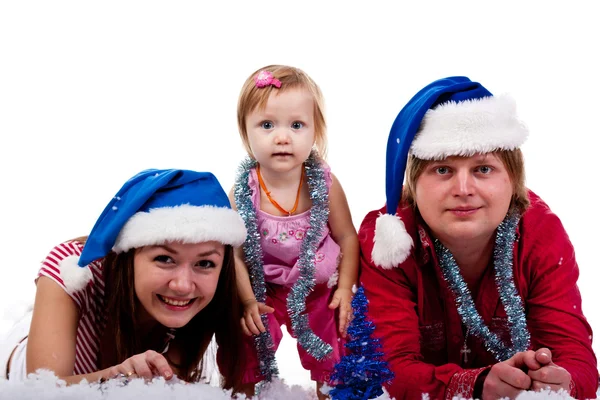 Rodina v Santa klobouk leží v umělém sněhu — Stock fotografie