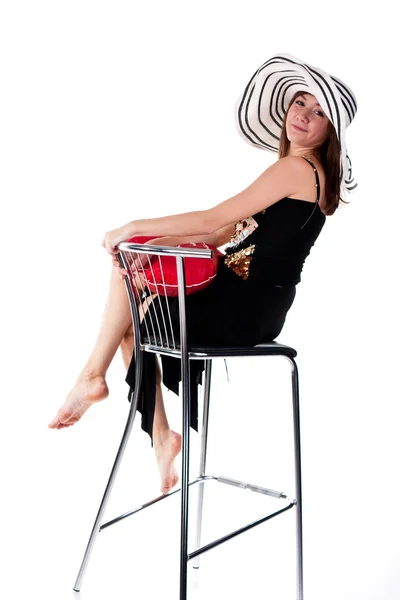 Menina bonita sentada em uma cadeira de bar com travesseiro coração vermelho — Fotografia de Stock