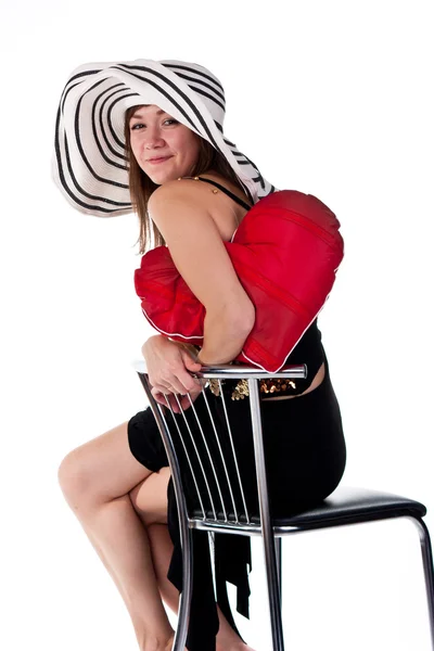 Hermosa joven sentada en una silla de bar con almohada de corazón rojo — Foto de Stock