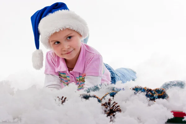 美丽的女孩在圣诞老人的帽子在金银丝帛和人工雪上白色孤立 — 图库照片