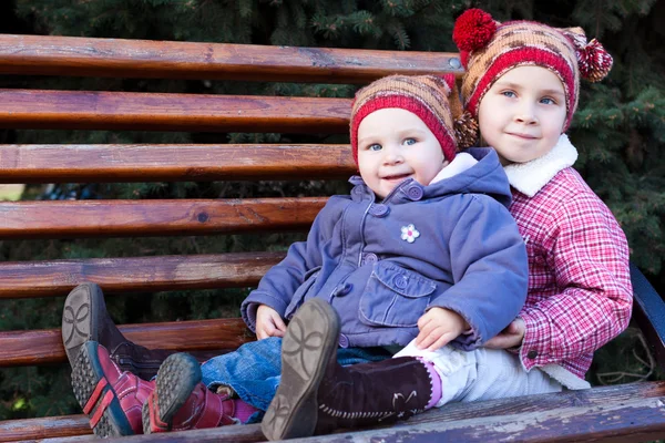 Barn som sitter på en bänk — Stockfoto