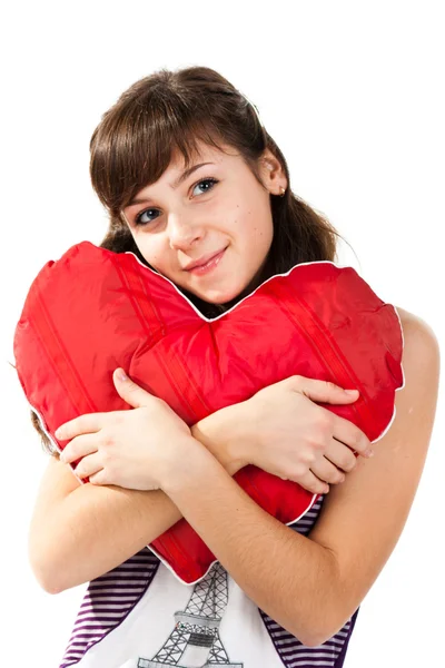 Beautiful girl with heart shaped red pillow — Stock Photo, Image