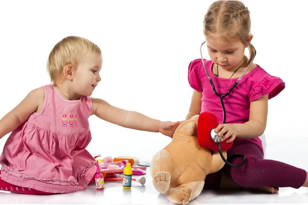 stock image Children playing doctor with a doll