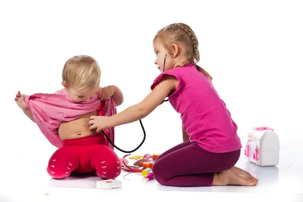 Děti si hrají lékaře s panenkou — Stock fotografie