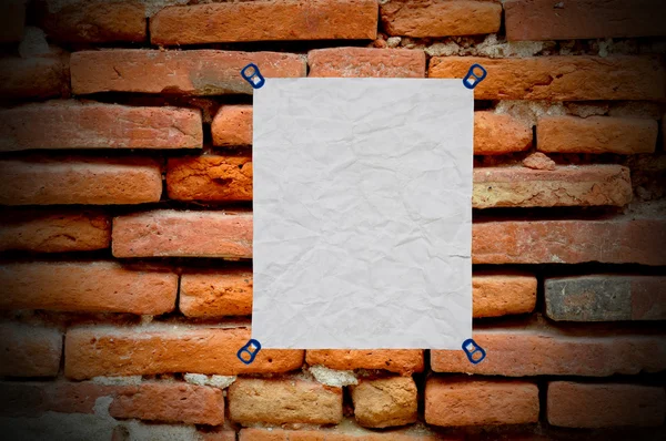 Blanco papel usado sobre fondo de pared de ladrillo — Foto de Stock