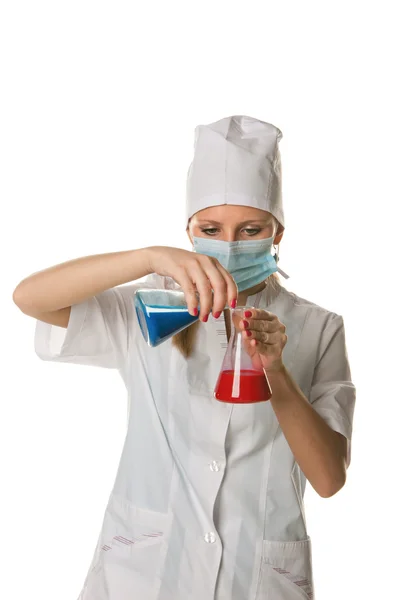 Mladý ženský vědec drží dvě barevné baňky - izolované na bílém — Stock fotografie