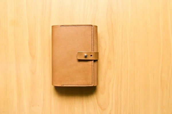 Leather case notebook on wood background — Stock Photo, Image
