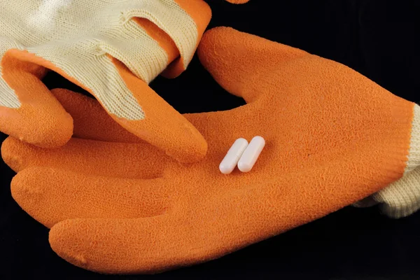 L - карнітин капсули, розміщені на робочих рукавичках — стокове фото