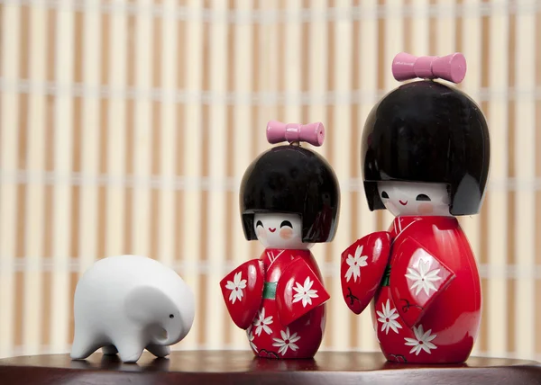 Duas pequenas bonecas japonesas e um pequeno elefante — Fotografia de Stock
