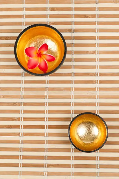 Deux bols dorés sur le tapis de bambou — Photo