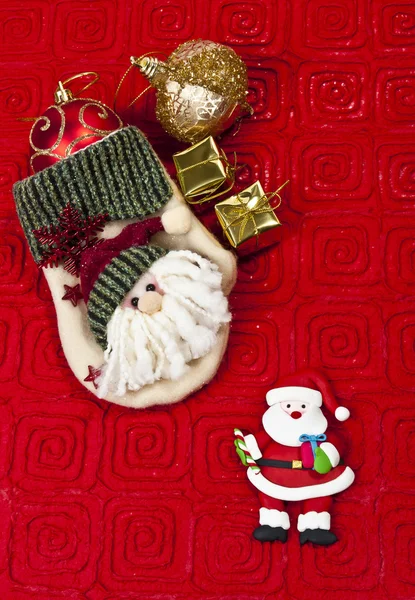 Weihnachtsmann-Handschuh auf rotem Papier Hintergrund — Stockfoto