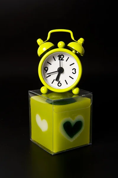 Precioso reloj verde en la parte superior vela verde —  Fotos de Stock