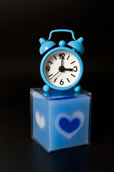 黒の背景に分離された青キャンドルに素敵な青い時計 — ストック写真