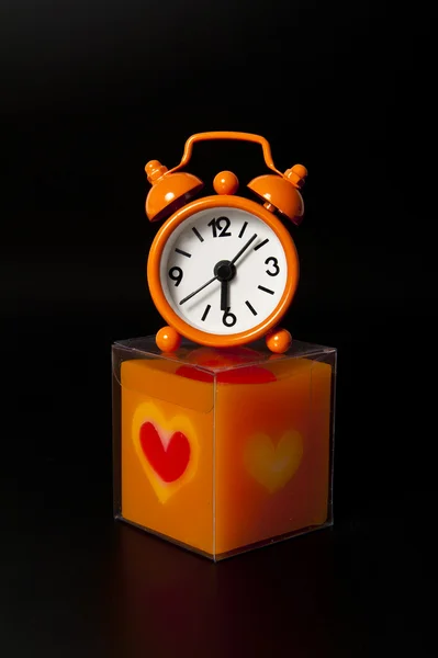 Schöne orangefarbene Uhr oben orangefarbene Kerze — Stockfoto