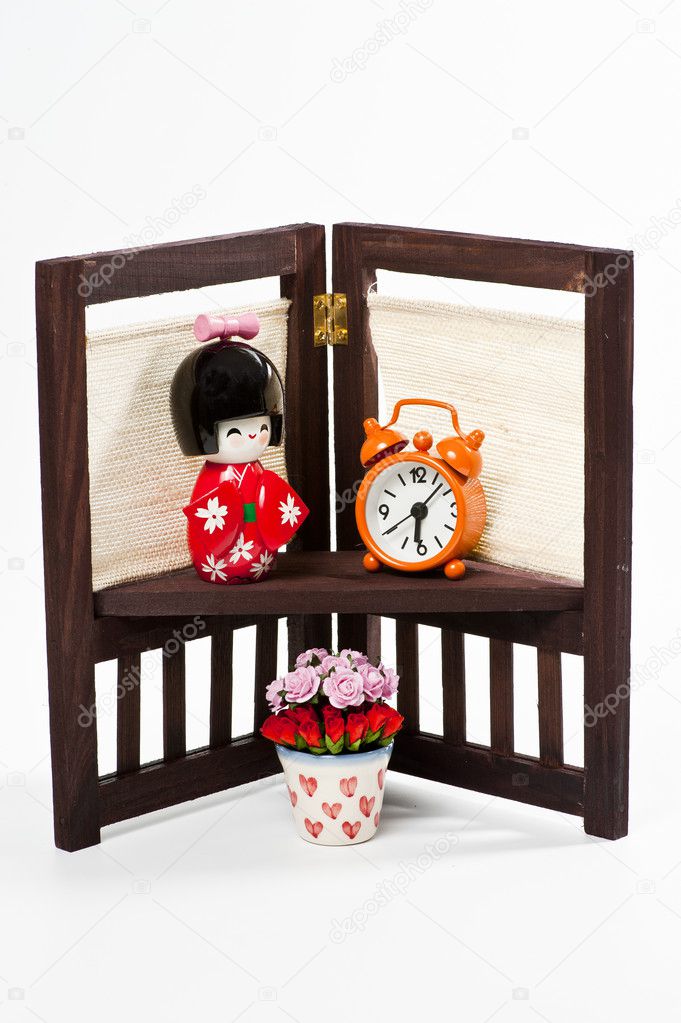 Japanese doll and orange clock on flower stand