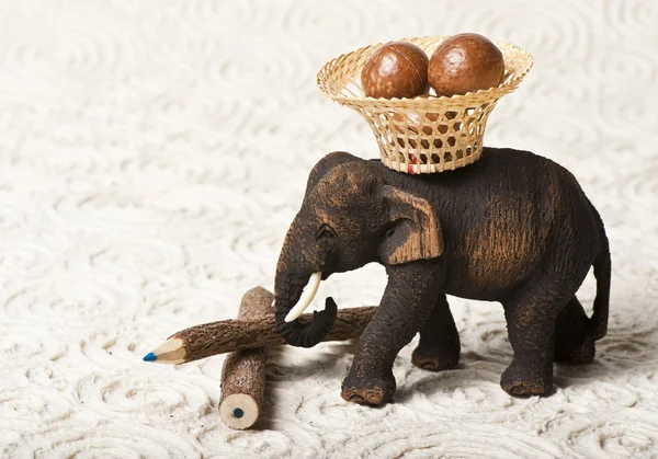 Drewniane słoń nosić nakrętki w koszyku — Zdjęcie stockowe