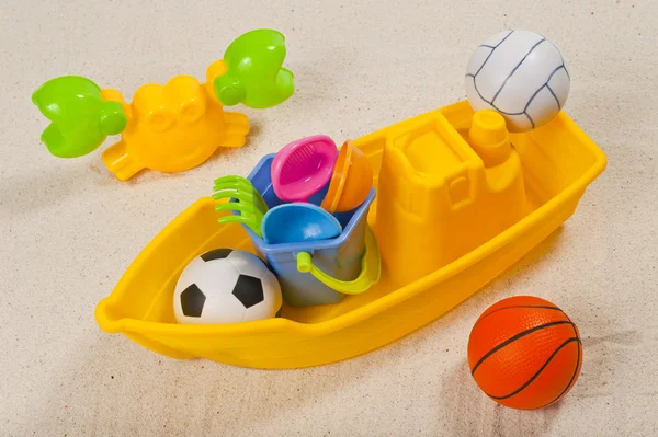 Plastic toy and ball on sand — Stock Photo, Image