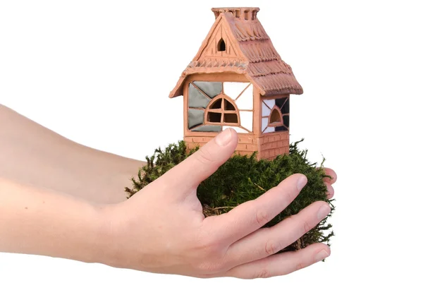 Clay house on moss in hands — Stock Photo, Image
