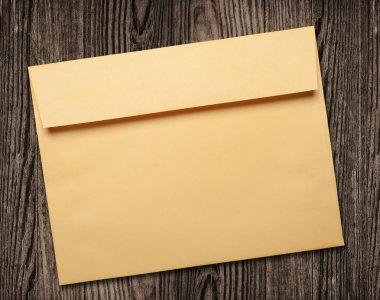 Golden envelope on wooden table. clipart