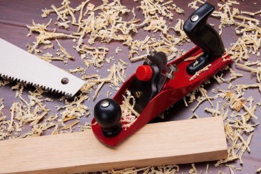 Red plane, wooden brick, handsaw and shavings clipart