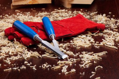 Chisels, red gloves and wood shavings clipart