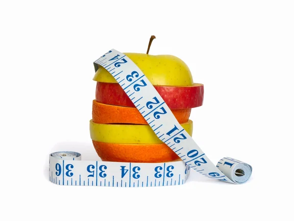 stock image Slices of apples and orange as one fruit and a measuring tape