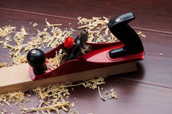 Red plane on brick and shavings. — Stock Photo, Image