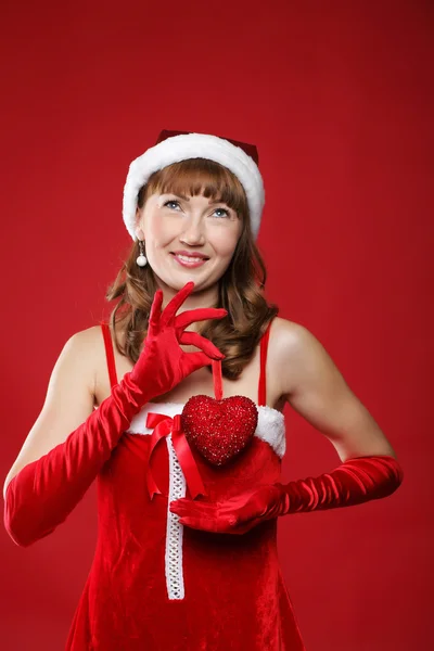 Young charming girl dressed as Santa holds a gift in the form of heart in h — Stock Photo, Image