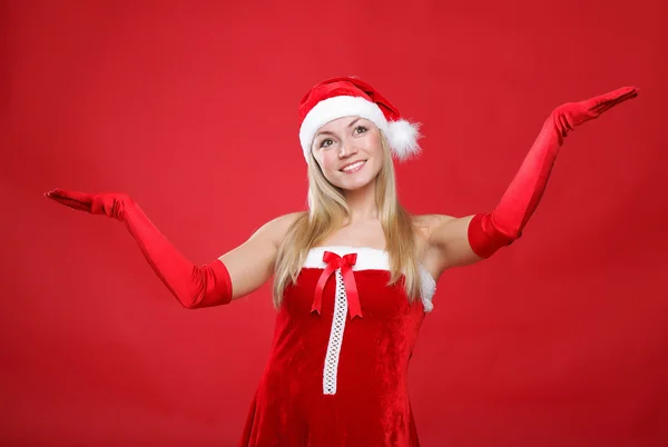 Menina vestida de Papai Noel em um fundo vermelho — Fotografia de Stock