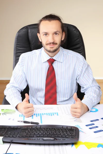 Businessman at his workplace hold thumbs up. — Stock Photo, Image