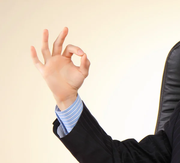 Uomo d'affari sul suo posto di lavoro mostra gesto con le dita . Foto Stock Royalty Free