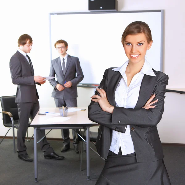 Portret van zakenvrouw met team-mates bespreken op de achtergrond Stockfoto