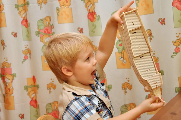 O menino recolhe modelo de veleiro de madeira — Fotografia de Stock