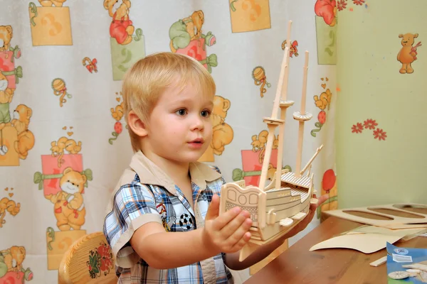 小さな男の子が収集モデル木製帆船 — ストック写真