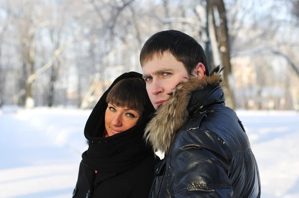 Ungt par på en promenad i parken i vinter — Stockfoto