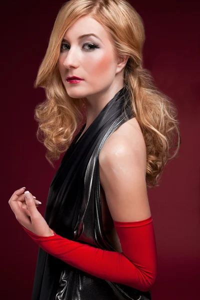 Идеальная блондинка в черном платье на красном — стоковое фото