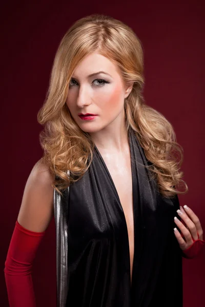 Perfekte Blondine im schwarzen Kleid auf Rot — Stockfoto