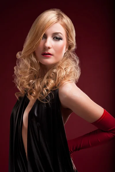 Dokonalá blondýna v černých šatech na červené — Stock fotografie