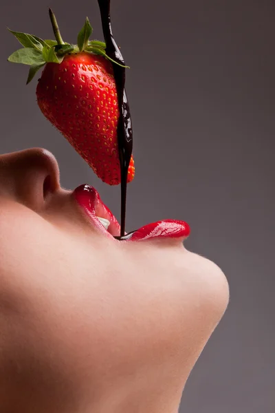 Dívku jíst jahody s čokoládovou sauc — Stock fotografie
